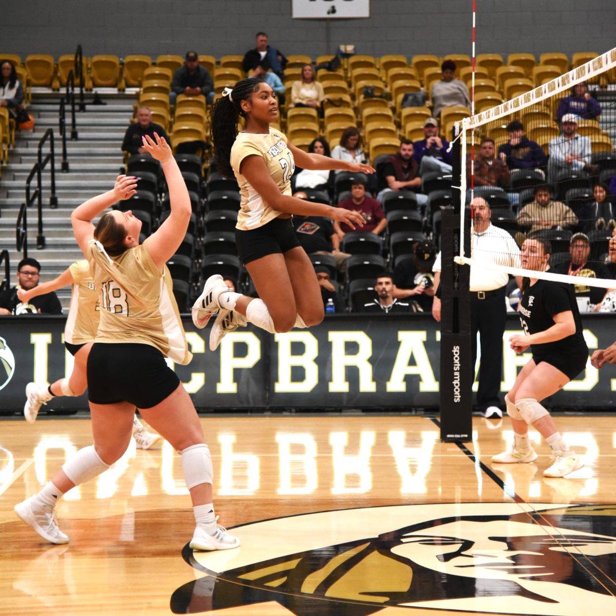 UNC Pembroke’s No. 24 Alexandria Mills soars for a kill as No. 18 Tyler Patterson tracks the ball during Friday’s five-set battle against Converse at Lumbee Guaranty Bank Court. PN// Michela Gritti